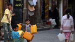 کودکان یمنی ظرف هایی را برای پر کردن با آب در دست دارند.